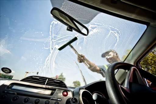 Window washers wash a motorist's windscreen at a traffic light in Pretoria on March 14, 2012. Picture GALLO IMAGES