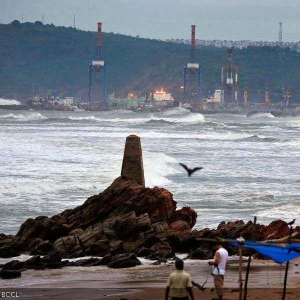 People watch as waves from the Bay of Bengal approach the shore in Visakhapatnam district in the southern Indian state of Andhra Pradesh.