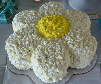 This birthday cake frosted and shaped like a daisy flower is unique. 