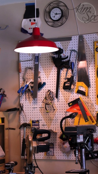 Red hanging light over woodworking bench