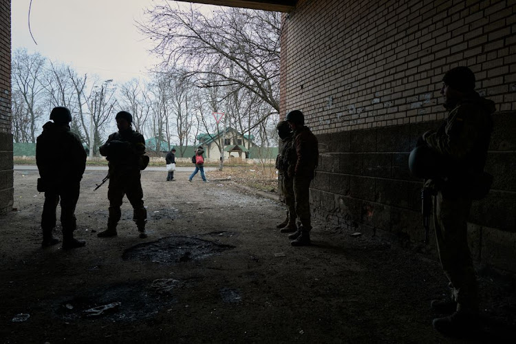 Ukrainian soldiers of the 12th brigade hide from a drone amid artillery shelling on December 24, 2022 in Bakhmut, Ukraine. Ukraine's hard-hit frontline city of Bakhmut is an eastern industrial city which Russia has attacked relentlessly for months with frontal assaults, artillery barrages and air strikes, had a pre-war population of around 70,000.