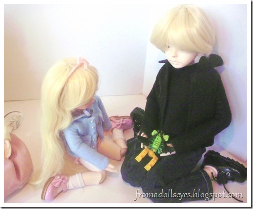 A yosd sized ball jointed doll holding a cool looking toy from a Kinder Joy pack.  She is showing it to a larger male ball jointed.