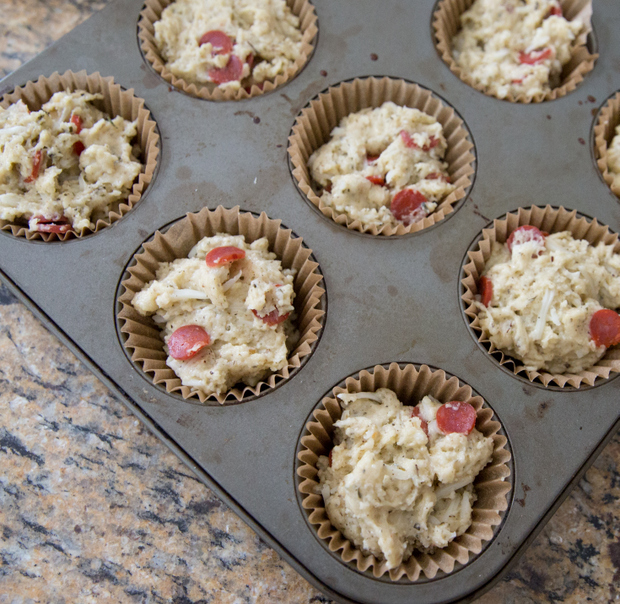 overhead photo of the dough in a muffin tip with pepperonis on top