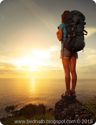 Tourist with backpack standing on a rock and looking to a sea; Shutterstock ID 121644487; PO: test; Job: dev; Client: drone