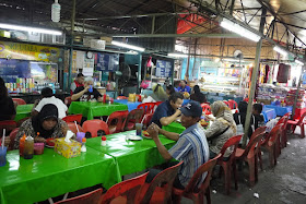 people eating at tables at Bazaar Baru Chow Kit in Kuala Lumpur, Malaysia