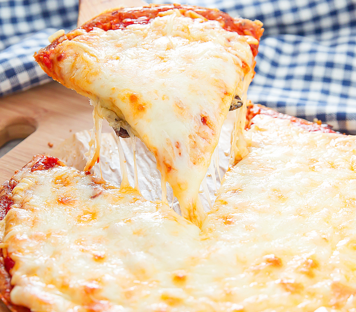 a photo of a piece of pizza being picked up with a spatula