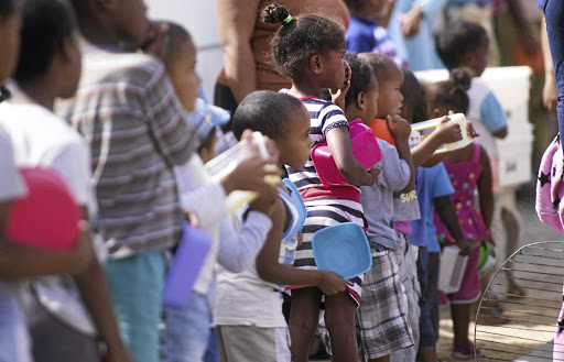 Children in Lavender Hill, Cape Town, queue for food supplied by civil society amid the national lockdown following the coronavirus pandemic. / Brenton Geach/ Gallo Images