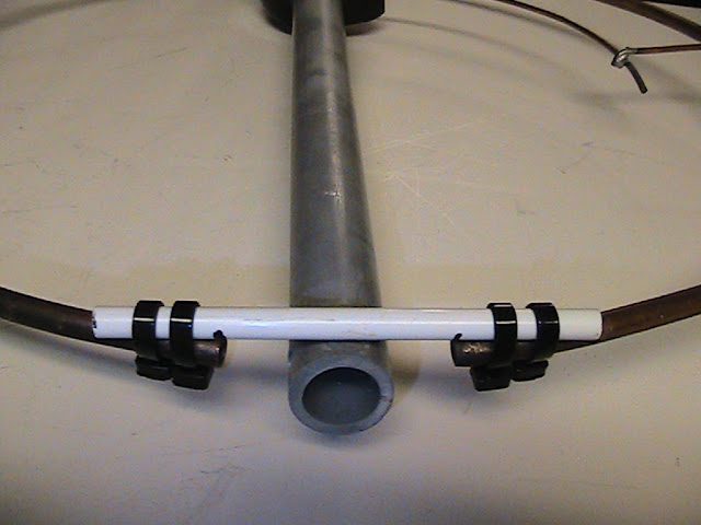 The resonant frequency of the antenna will vary with the distance between these open ends.  
After adjustment, UV resistant cable ties and a piece of 1/4 inch fiberglass rod on the open ends of the halo antenna secure the gap spacing.
The open end of the boom will later be weatherproofed with self-sealing silicone tape.