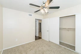 Corner of bedroom looking at door and closet with sliding door