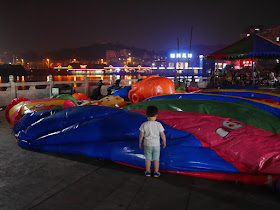 child looking at a deflated slide ride at Donghu Park in Zhuzhou, Hunan