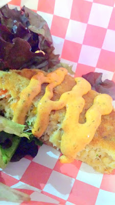 Maine Street Lobster Company's local Dungeness crab cake served on a bed of spring mix and topped with house remoulade and chives