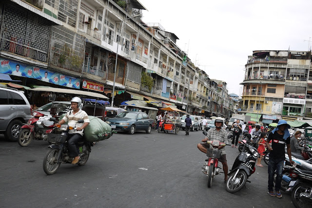 man carrying a large bag on a motorbike