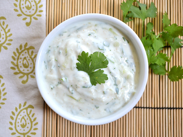 Top view of a bowl of Cucumber Raita garnished with cilantro 