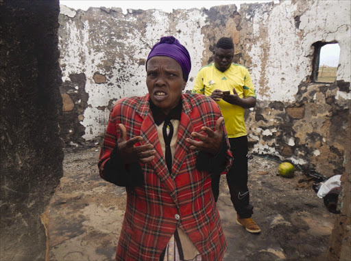 ELP AT HAND: Lightning victim Nolusapho Mazini inside her rondavel, which caught fire after being struck by lightning in Qunu. Behind her Nelson Mandela’s grandson Siya Mandela, who is helping her with groceries and other necessities Picture: LOYISO MPALANTSHANE