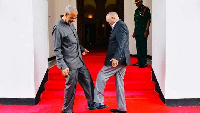 President John Magufuli (R) exchanges foot greeting with opposition politician Seif Sharif Hamad to promote “no handshake” in Tanzania.