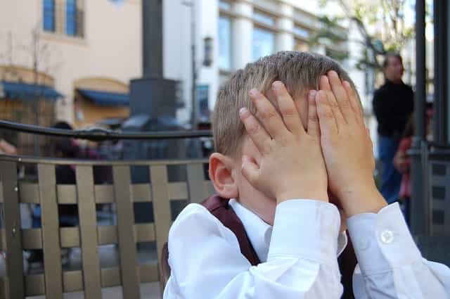 Boy covering his face in shame