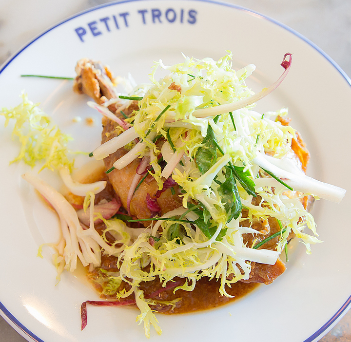 overhead phot of CONFIT-FRIED CHICKEN LEG with brioche butterand frisée salad