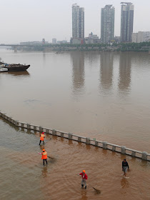 workers sweeping silt away from a submerged pedestrian area