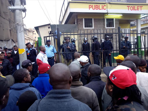 Police officers keep guard at OTC public toilet amid management wrangles between youths and the intiial operators, July 18, 2018. /COURTESY