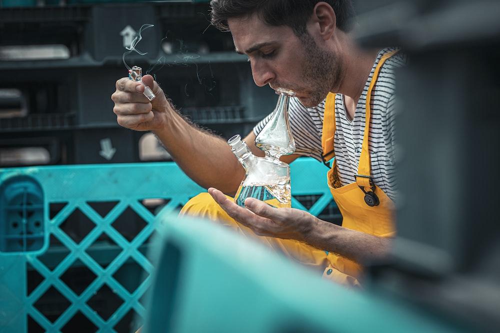 man using glass smoking device