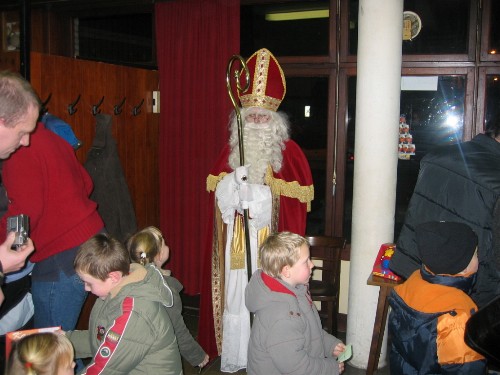 De Sint kijkt streng toe dat alle brave bengels hun cadeautje krijgen.