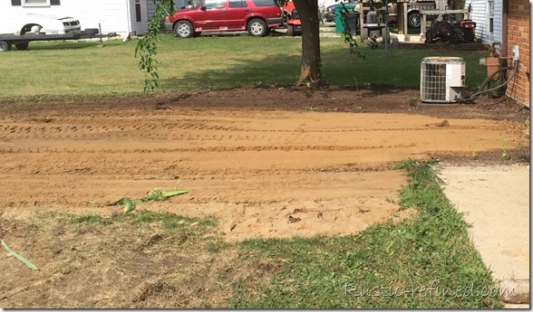 using sand and a bobcat to fill in an old septic tank