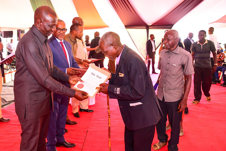 President William Ruto issuing title deeds to a resident of Ciampiu in Mwingi North, Kitui County on July 13,2023.