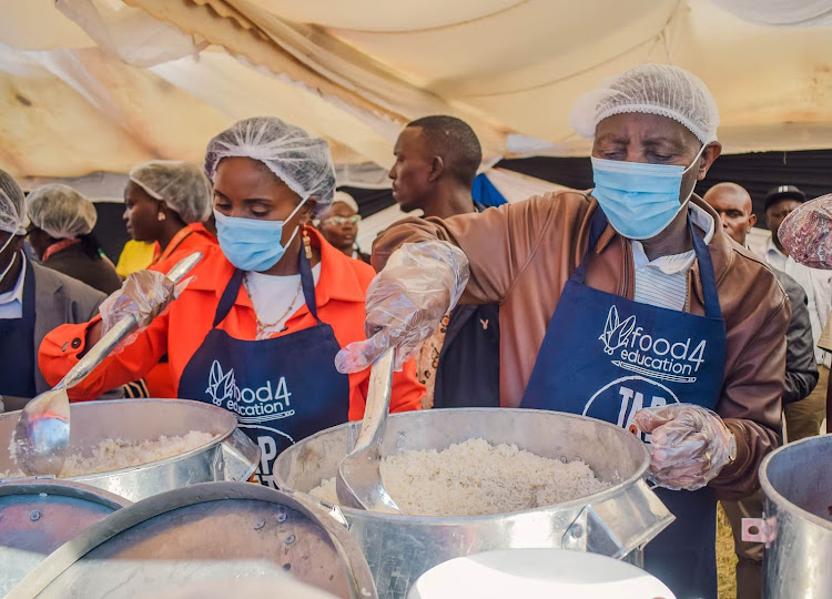 Thika MP Alice Ng'ang'a and her Limuru counterpart John Kiragu serve pupils with food at Kamandura Primary School in Kiambu County, March 23, 2024.