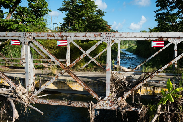 This bridge in Naguabo, Puerto Rico is still filled with debris a year after the flood waters rose during Hurricane Maria. Photo: Sarah L. Voisin