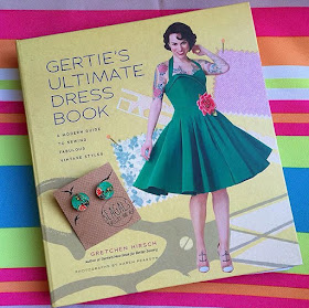 Gertie's ultimate dress book featuring woman with green rockabilly dress, plus green earrings. 