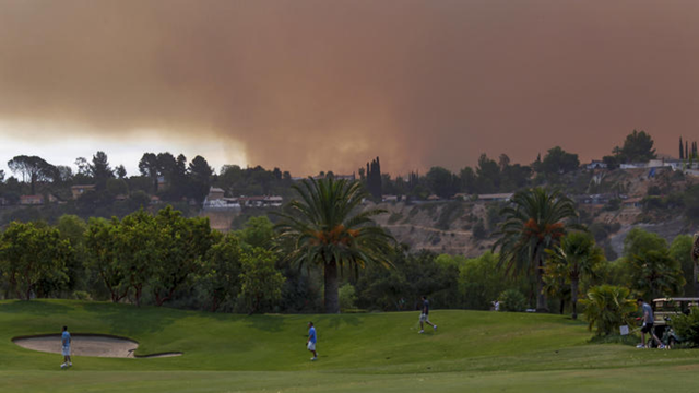 Golfers at Angeles National Golf Course play while the La Tuna fire burns nearby in the Verdugo Hills above Sunland-Tujunga, 2 September 2017. Photo: Irfan Khan / Los Angeles Times