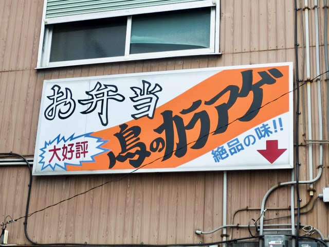 「お弁当、大好評、鳥のカラアゲ、絶品の味」と書かれた看板