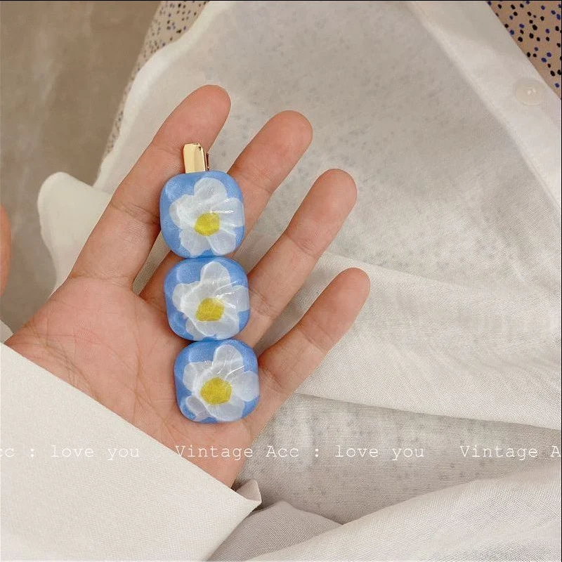 Boucles d'oreilles Daisy avec barrette à fleurs bleues, l'ensemble idéal pour un look frais et féminin. Sublimez vos cheveux et oreilles.