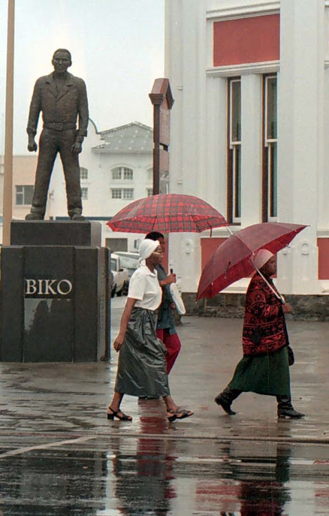 Women walk past the statue of Steve Biko in East London.