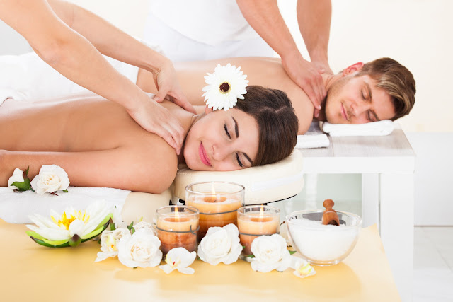 Portrait of smiling young couple receiving massage at spa