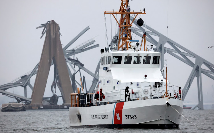 A US Coast Guard vessel sails near the Francis Scott Key Bridge, after the Dali cargo vessel crashed into it causing it to collapse, in Baltimore, Maryland, the US, March 27 2024. Picture: REUTERS/Mike Segar