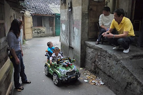 several people watching boy in an electric toy car near Beizheng Street in Changsha, China