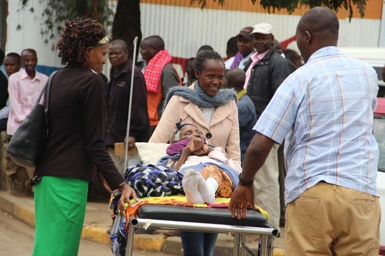 Family members remove their sick relative from a ward on September 9 as workers strike began at the Kenyatta National Hospital