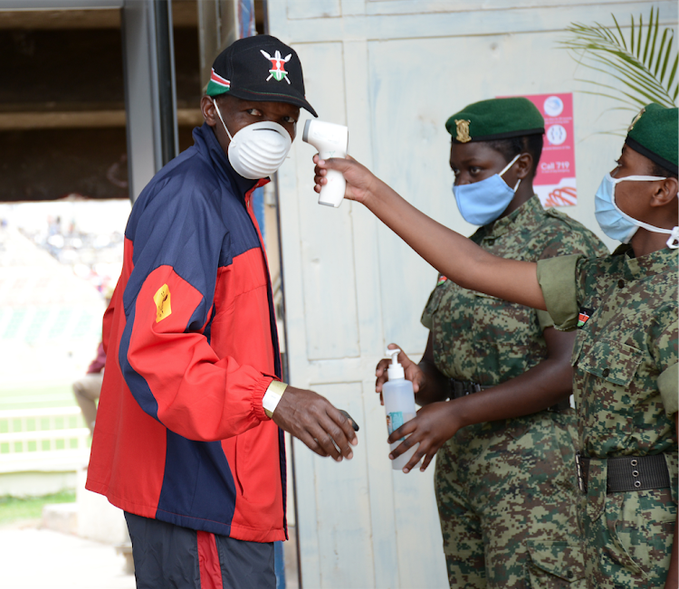 National Youth Service officers conduct Covid-19 protocols at the Nyayo Stadium gates during the Kip Keino Classic Continental Tour