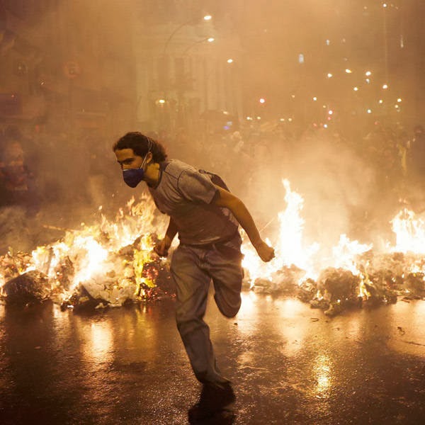 A demonstrator from the group called Black Bloc runs outside the Municipal Assembly during a protest supporting a teachers' strike in Rio de Janeiro.