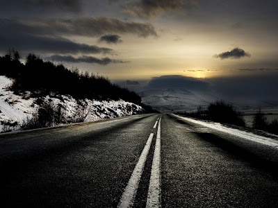 empty highway goin off into dark clouds