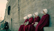 Handmaids take a breather at a gallows for dissidents during a shopping trip in 'The Handmaid's Tale' Season 1.