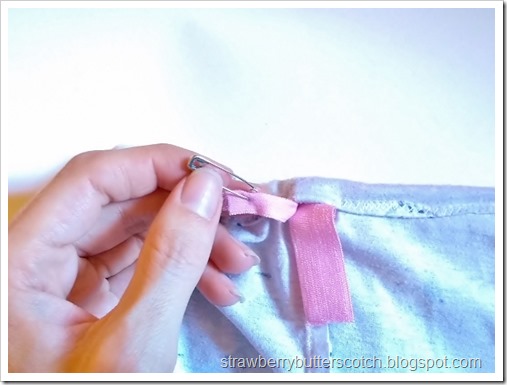 Pink elastic threaded through the casing with a safety pin to form the elastic waistband on the shorts. Pink elastic threaded through the casing with a safety pin to form the elastic waistband on the shorts.