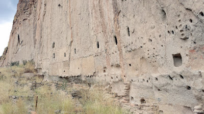 These cave rooms in the Bandelier National Monument, classified as cavates, were dug out of the cliff wall to create these cliff dwellings. This is Long House, multi-storied dwellings along a cliff base and with carved petroglyphs. You can count the stories by counting the rows of holes.