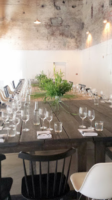 The dining table inside Jacobsen Salt Co. headquarters for the Salt Fire Water dinner series. The middle light brown portion is the original old original salt trailer he used when he first started. Ben Jacobsen dreamed of salvaging it to create a communal table that people would gather warmly like a family and enjoy incredible food - thus the Salt Fire Water dinner series