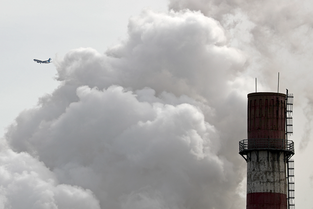 In this file photo taken Tuesday, 28 February 2017, a passenger airliner flies past steam and white smoke emitted from China Huaneng Group's Beijing power plant that was the last coal-fired plant to shut down on 18 March 2017 as the Chinese capital convert to clean energy like thermal power. Researchers say Tuesday, 25 April 2017 that China's conversion of coal into natural gas could prevent tens of thousands of premature deaths annually. But there's a catch: It also could undermine efforts to rein in greenhouse gas emissions. Photo: Andy Wong / AP Photo