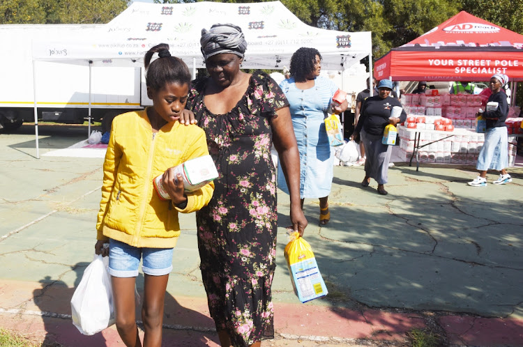 Residents of Motsoaledi informal settlement collect food parcels at Power Park in Soweto. Picture: FREDDY MAVUNDA