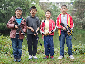 four Chinese boys holding toy guns