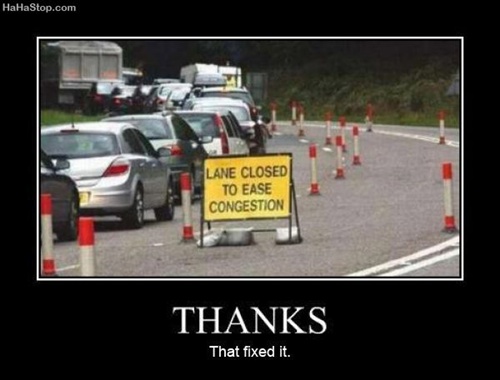 photo of a traffic jam and a road sign saying lane closed to ease congestion