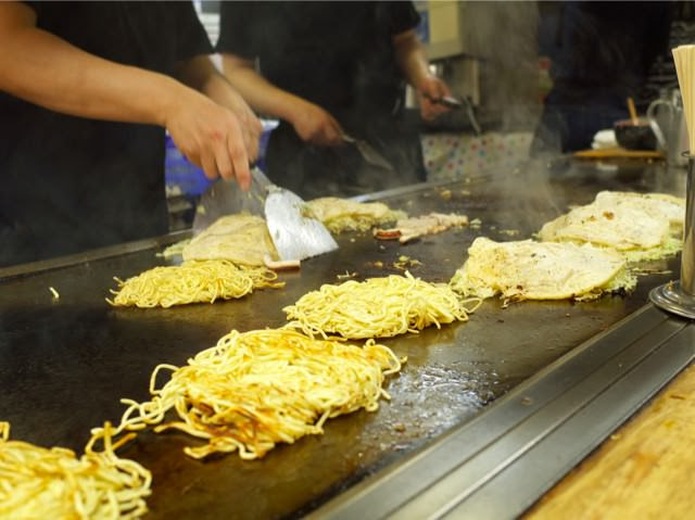 鉄板の上で作られてる、お好み焼き